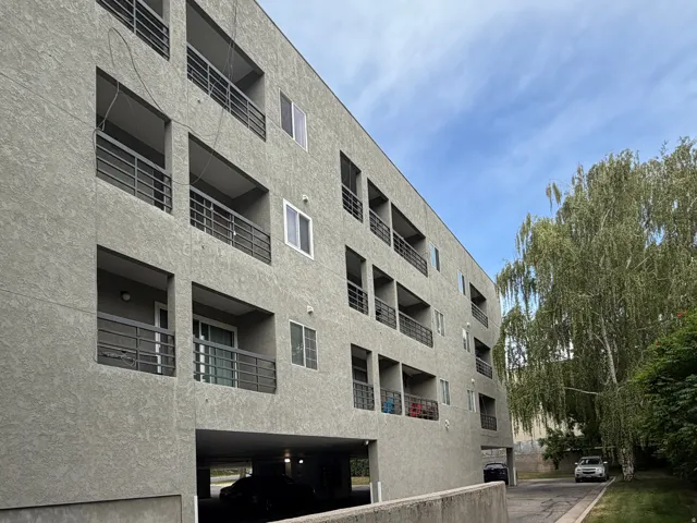 Contemporary multi-story building featuring stucco exterior and individual balconies with dark metal railings
