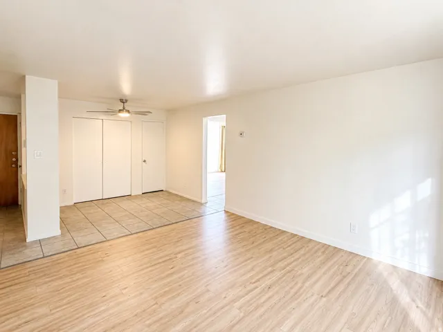 Spacious living area featuring wood-finish flooring and light-toned walls