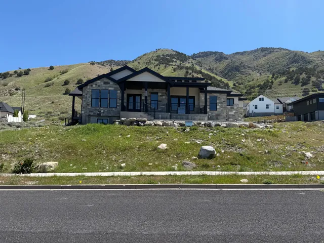 Modern mountain-style residence featuring a stone and siding exterior