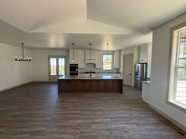 Open-concept kitchen and living area featuring wood-finish flooring