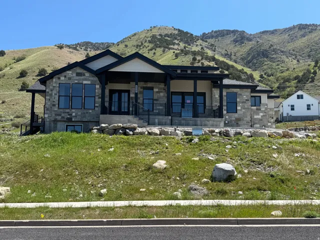 Contemporary residence featuring a stone and siding exterior with a prominent covered entry