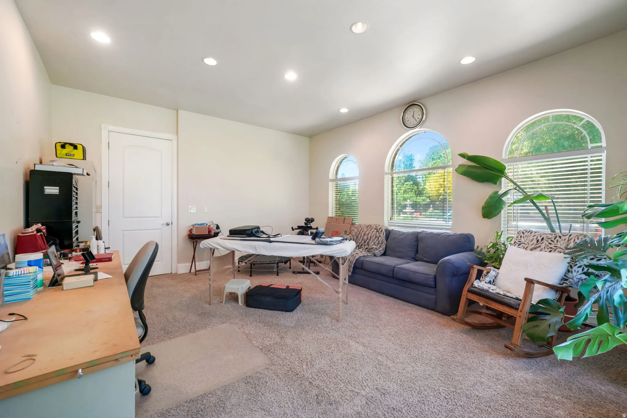 HUGE office adjacent to primary bedroom with multiple arched windows with blinds, recessed lighting, and light-colored carpeting