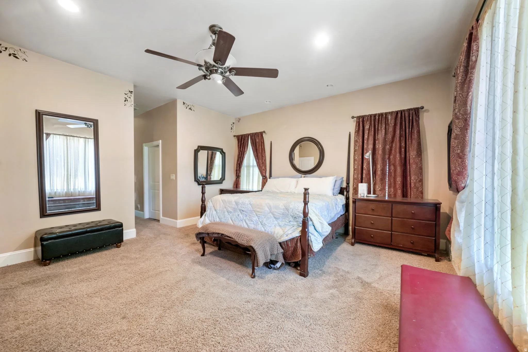 Main primary bedroom featuring a vaulted ceiling with a ceiling fan, recessed lighting, and wall-mounted mirrors