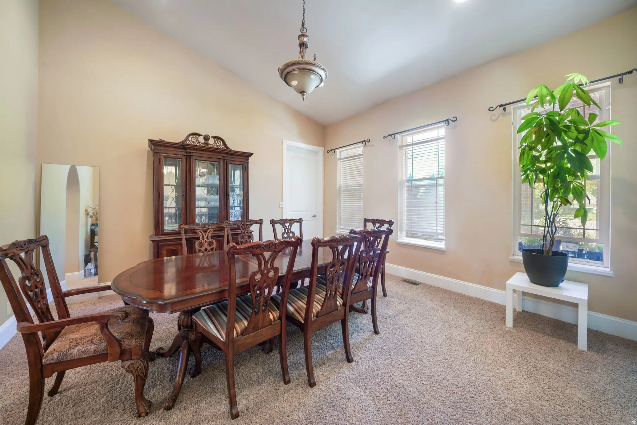 Formal dining right of entrance.  Vaulted ceilings, neutral-toned walls, and plush carpet flooring