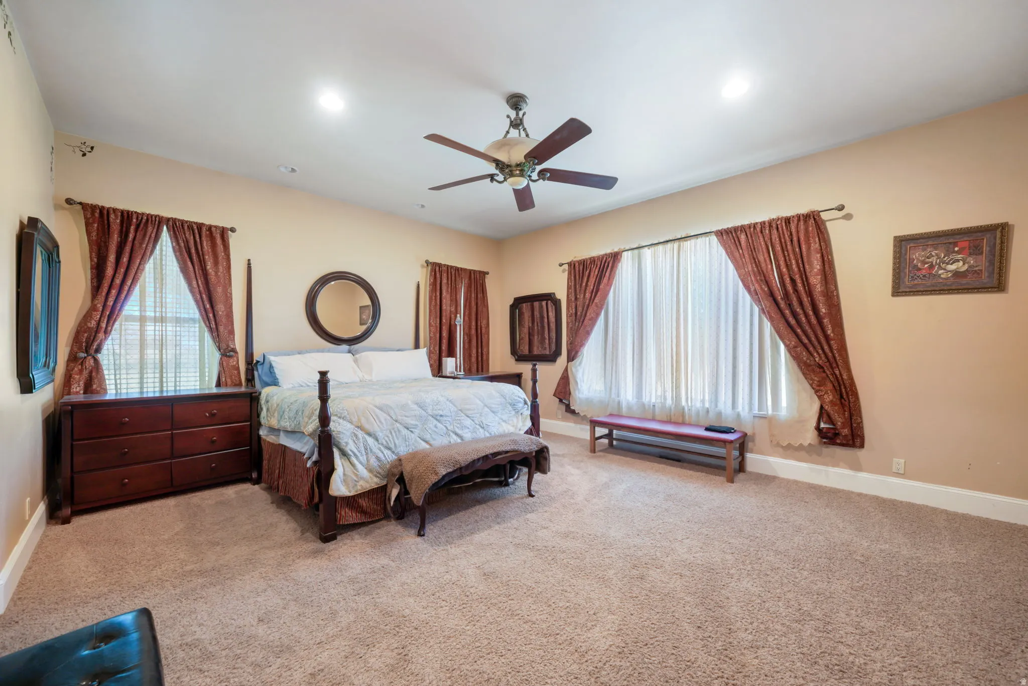 Spacious main primary bedroom featuring carpeting, recessed lighting, and a ceiling fan.