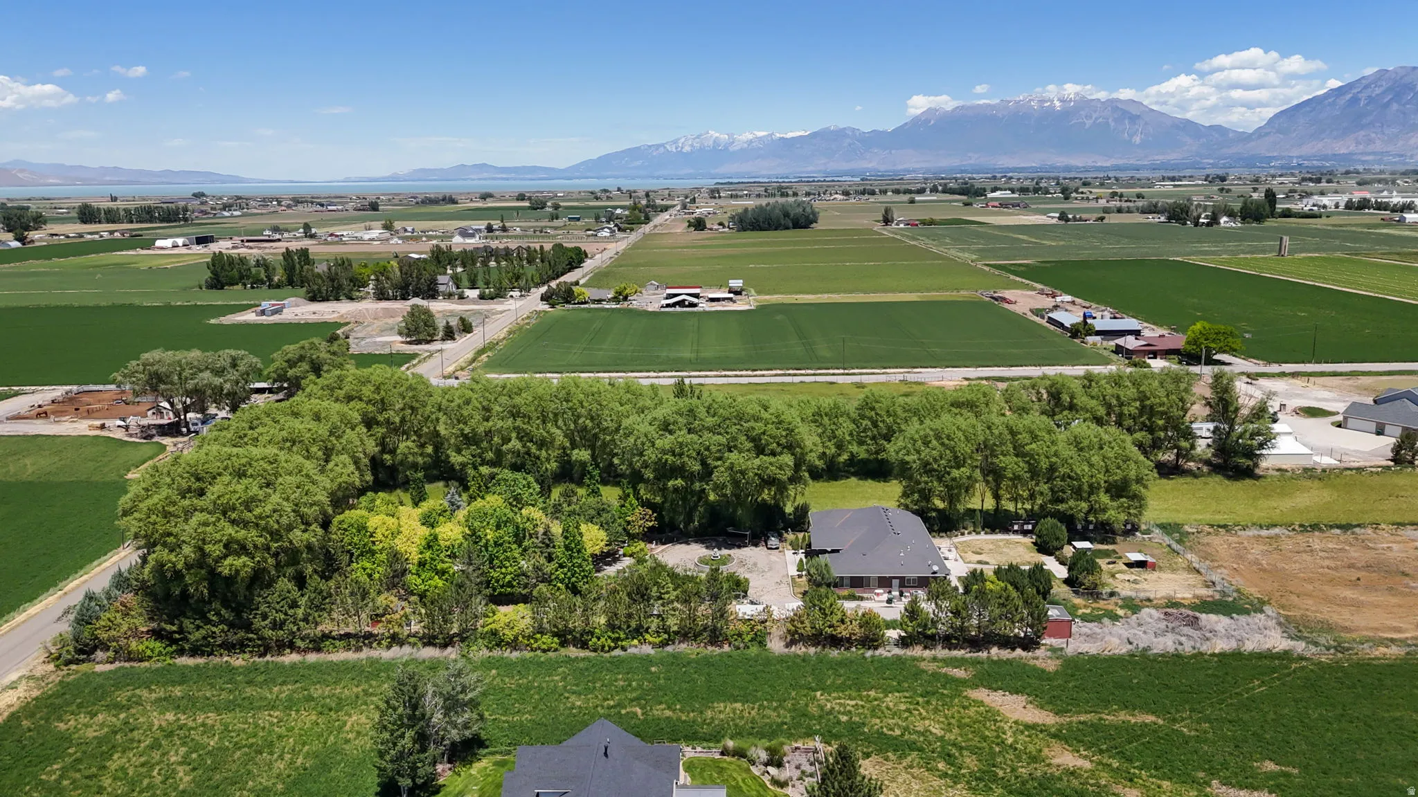 Expansive rural landscape featuring a single-story residence with a dark roof