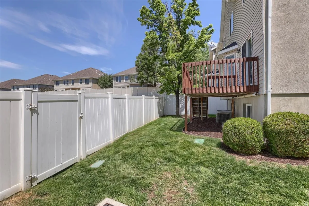 Expansive grass lawn bordered by a white privacy fence