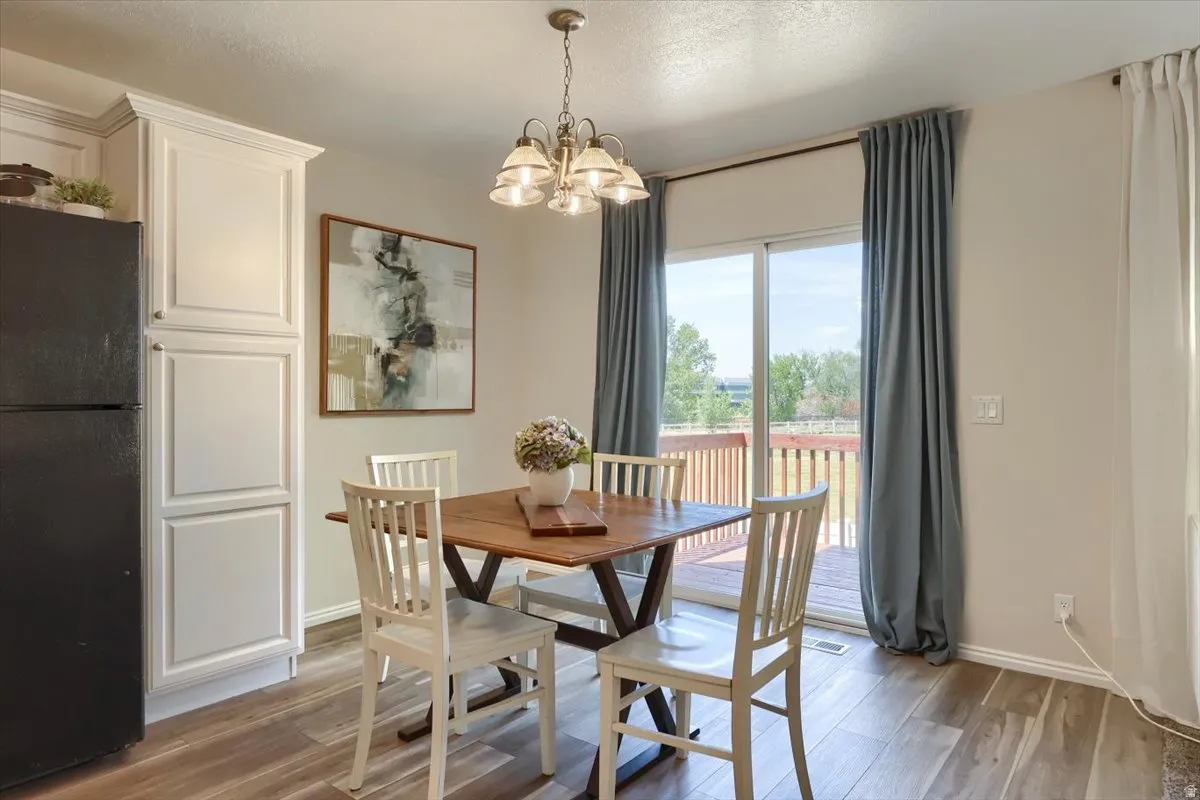 Dining area featuring wood-finish flooring and a contemporary chandelier