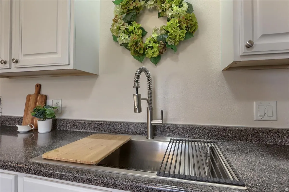 Kitchen sink with a high-arc pull-down faucet, undermount stainless steel sink, and speckled countertop