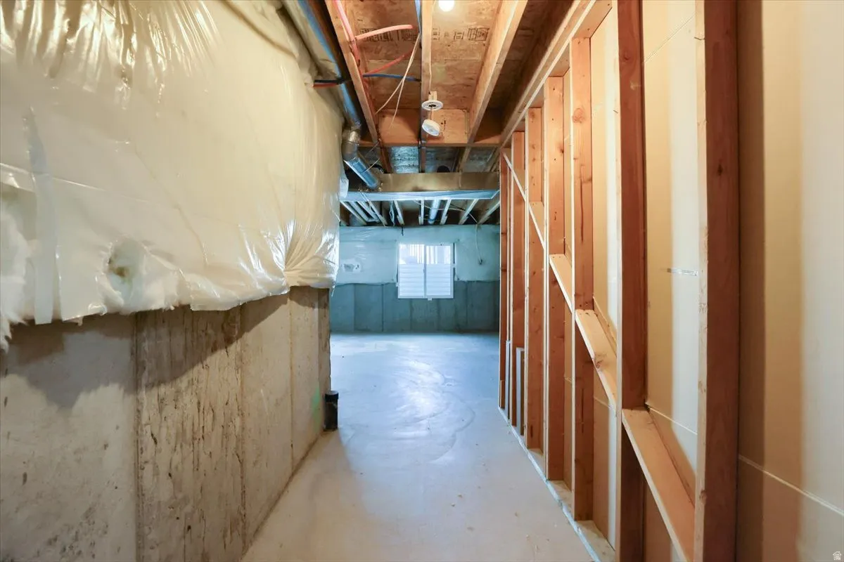 Unfinished lower level featuring exposed wooden studs, concrete walls, and a concrete floor