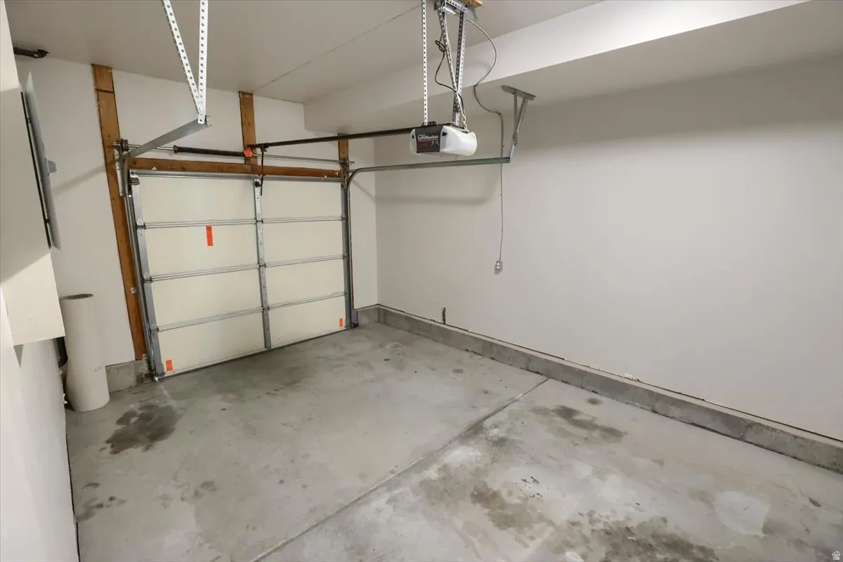 Interior garage featuring a paneled garage door and concrete flooring