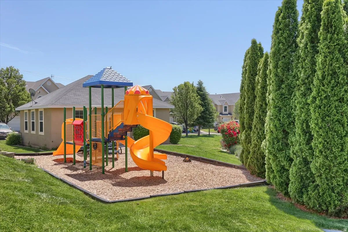 Outdoor recreational area featuring a multi-color play structure with slides and climbing elements