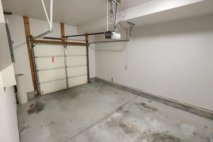 Interior garage featuring a paneled garage door and concrete flooring