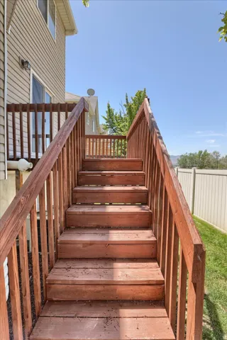 Wood-finish deck stairs with railings providing access to the property's exterior