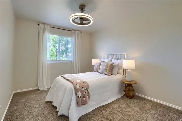 Bedroom featuring light tan walls and plush brown carpeting