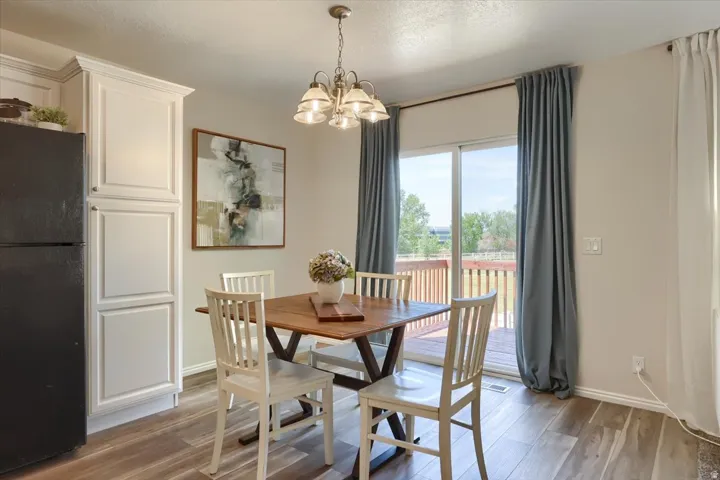 Dining area featuring wood-finish flooring and a contemporary chandelier