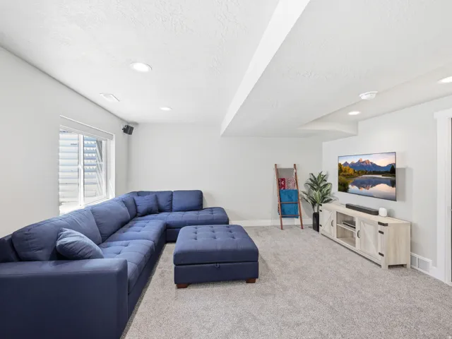 Carpeted room featuring a window, recessed lighting, and a wall-mounted television