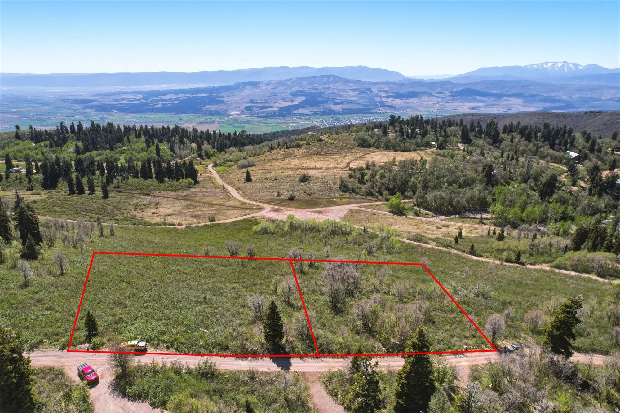 Two distinct parcels of land outlined in red, featuring varied topography with mature trees and natural vegetation