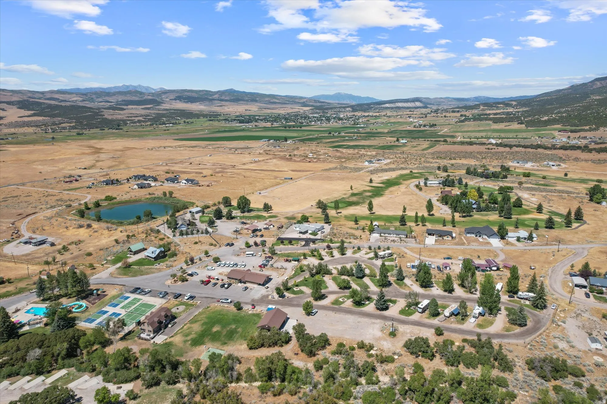 Expansive aerial perspective showcasing a community with diverse housing, recreational facilities, and natural landscape