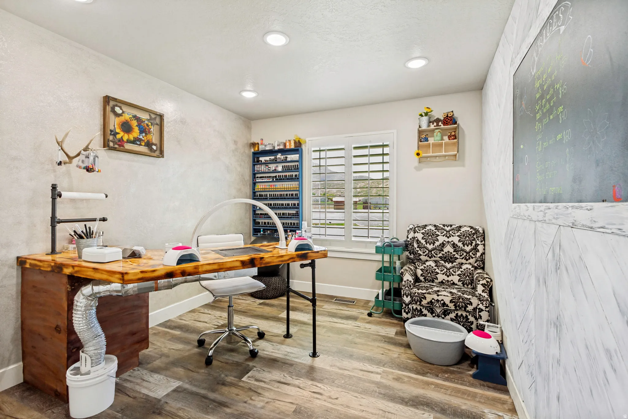 Room featuring wood-finish flooring, a window with plantation shutters, recessed lighting, and an accent wall with a chalkboard panel