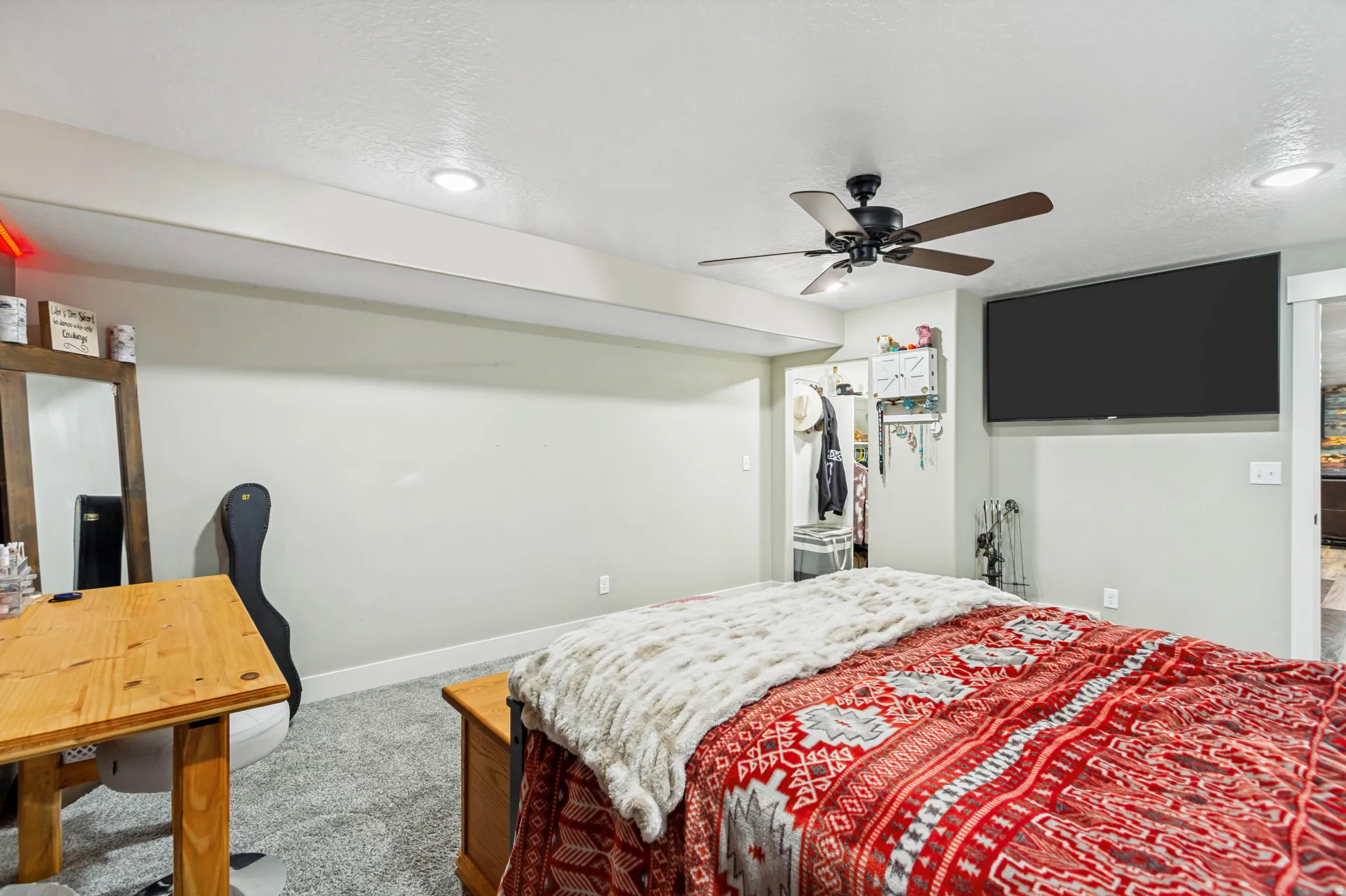 Carpeted room featuring recessed lighting, a ceiling fan, a wall-mounted television, and light-toned walls