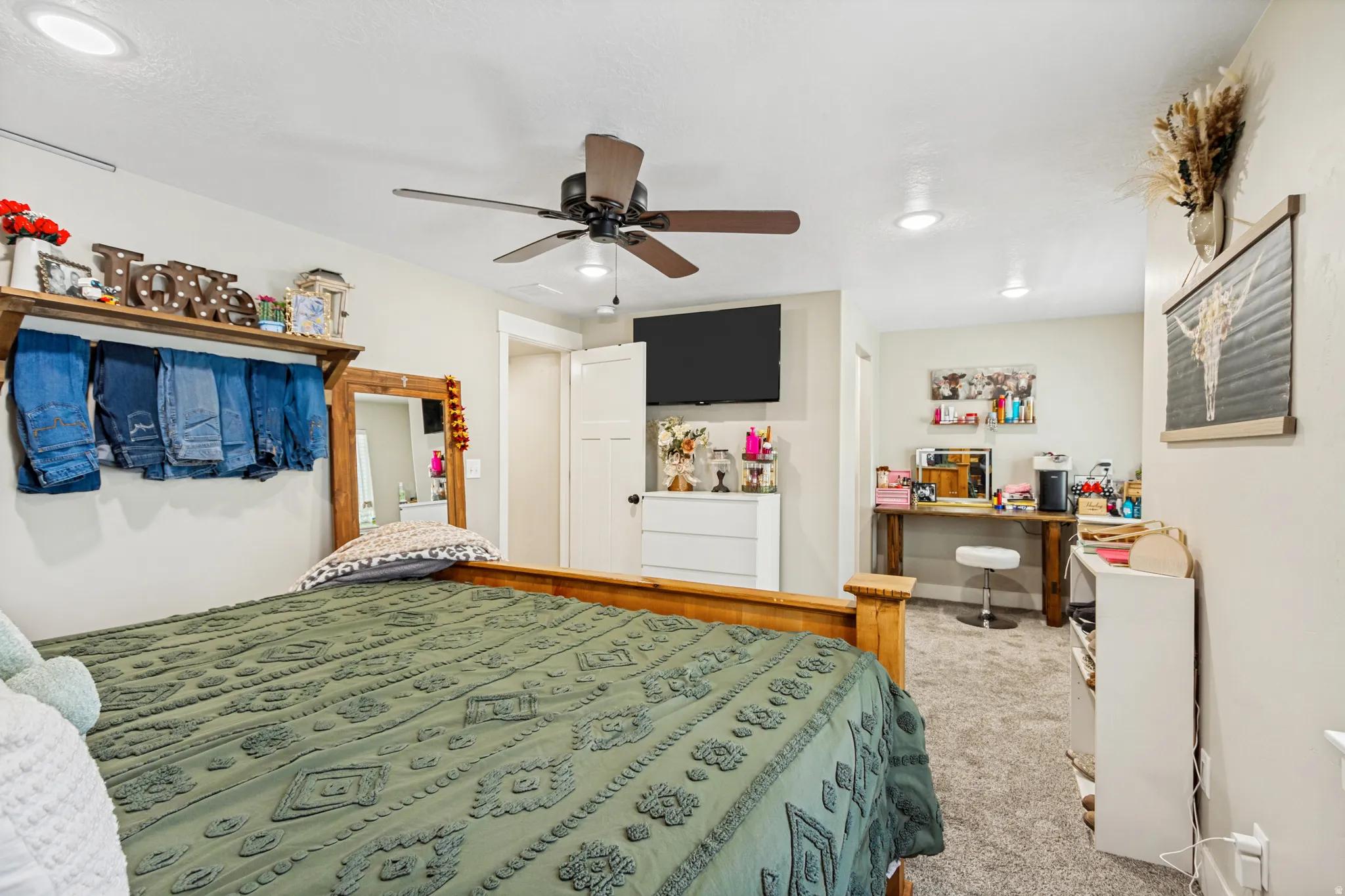 Carpeted bedroom featuring a ceiling fan with integrated lighting, recessed ceiling lights, and two white paneled doors