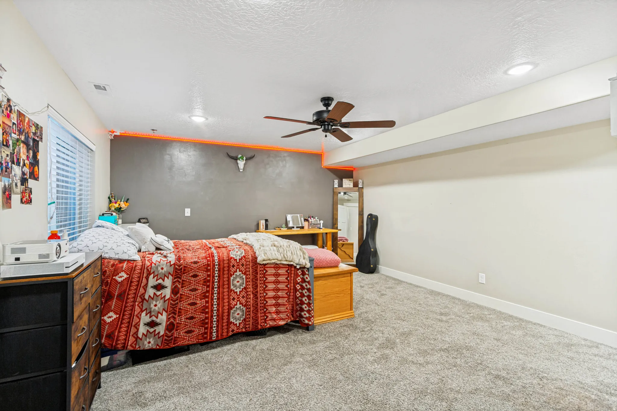 Spacious room featuring neutral carpeting, recessed lighting, and a ceiling fan