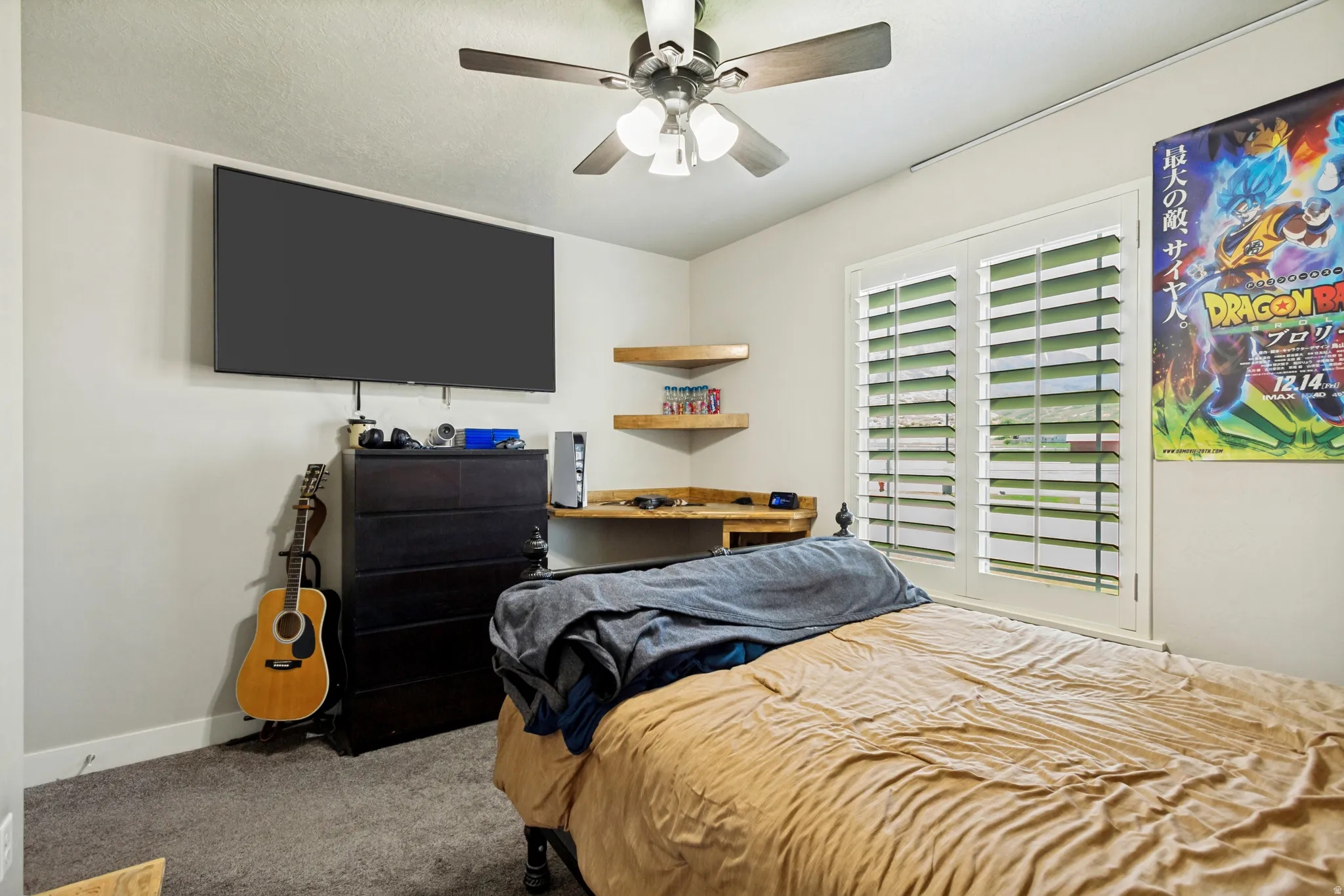 Bedroom featuring a ceiling fan, wall-mounted television, and carpet flooring