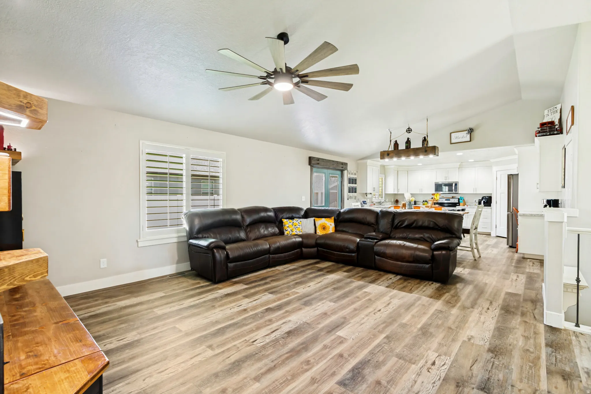 Open-concept living area featuring wood-finish flooring and vaulted ceilings