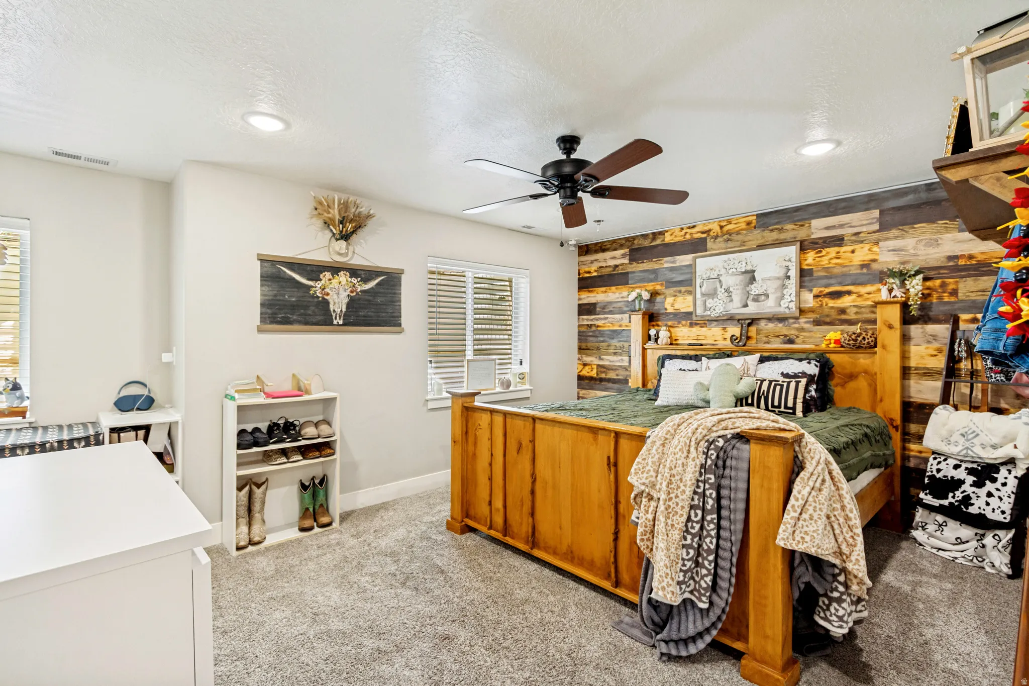 Bedroom featuring a wood-panel accent wall and recessed lighting