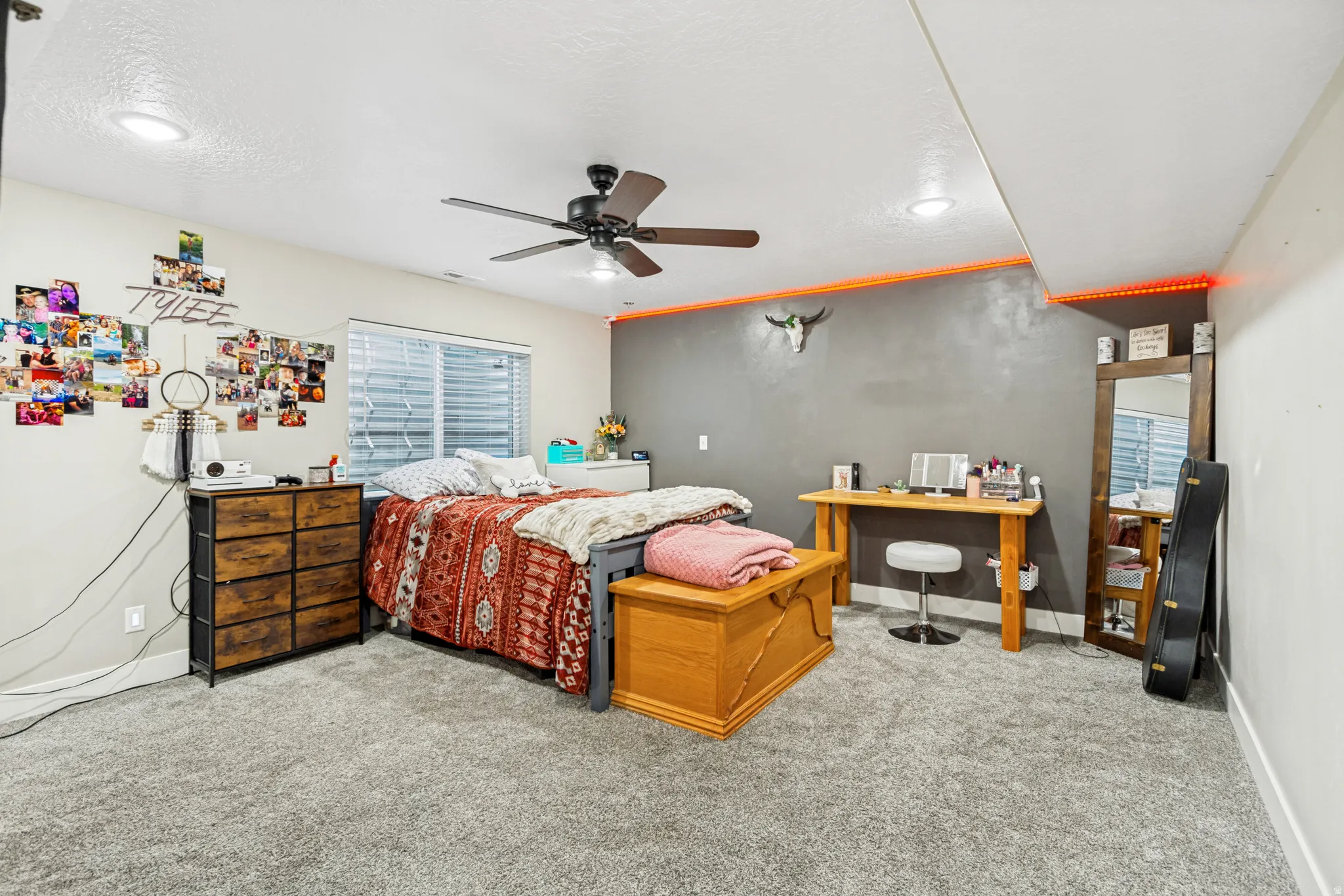 Spacious room featuring plush carpeting, a ceiling fan with integrated lighting, recessed ceiling lights, and a window with blinds