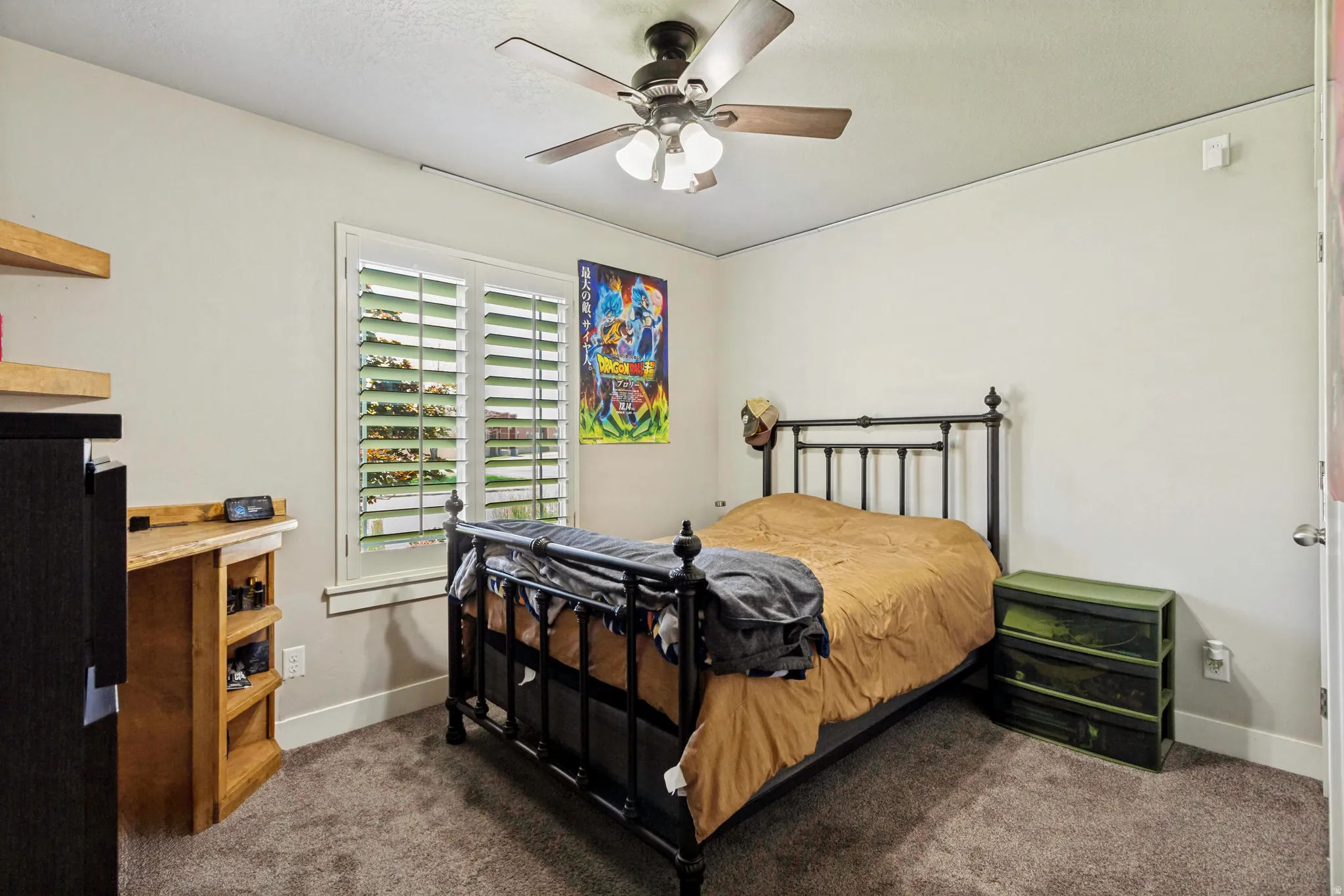 Room featuring plush carpet, a ceiling fan with integrated lighting, and a window with plantation shutters