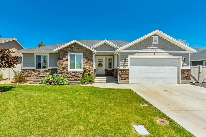 Ranch-style residence featuring a stone and siding exterior, a two-car garage, and a concrete driveway