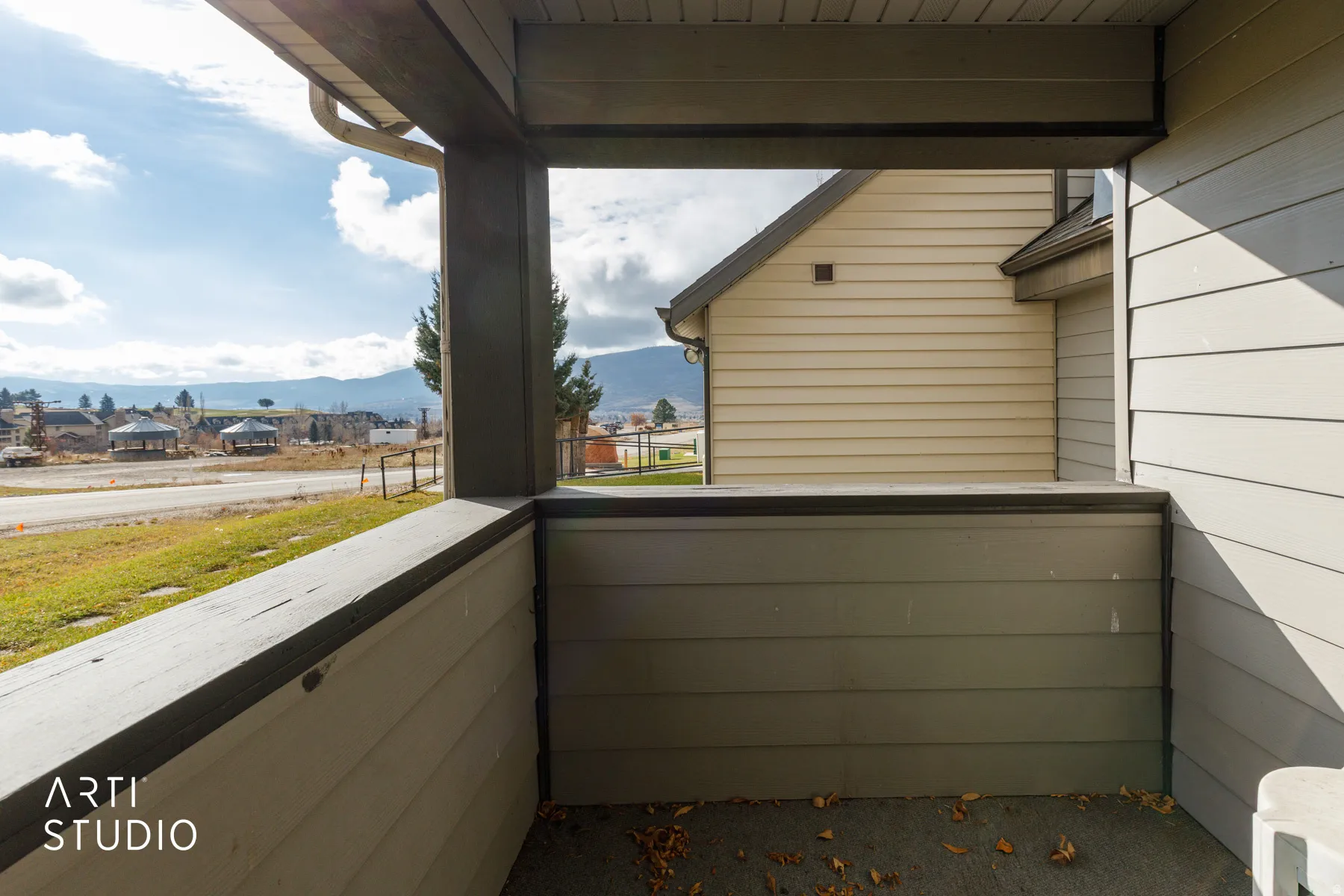 Covered outdoor space featuring a composite railing and mountain scenery