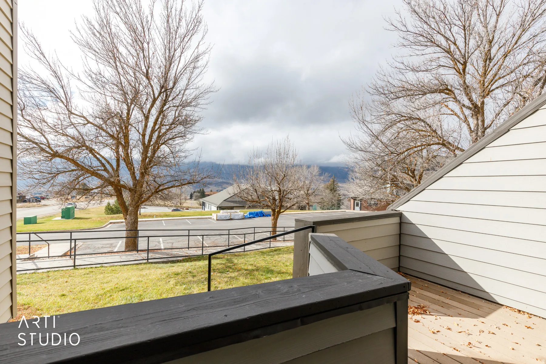 Outdoor deck featuring composite decking and railing, with a backdrop of distant mountains