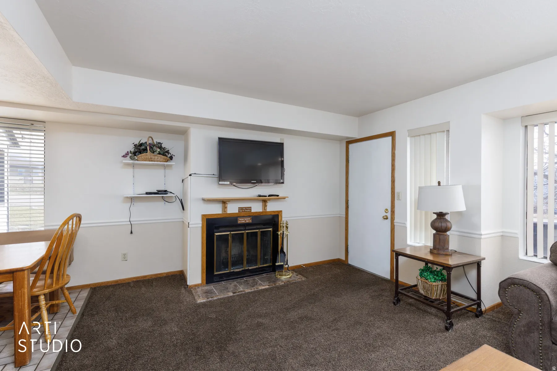 Living area featuring a fireplace with a black insert, wood mantel, and tile hearth
