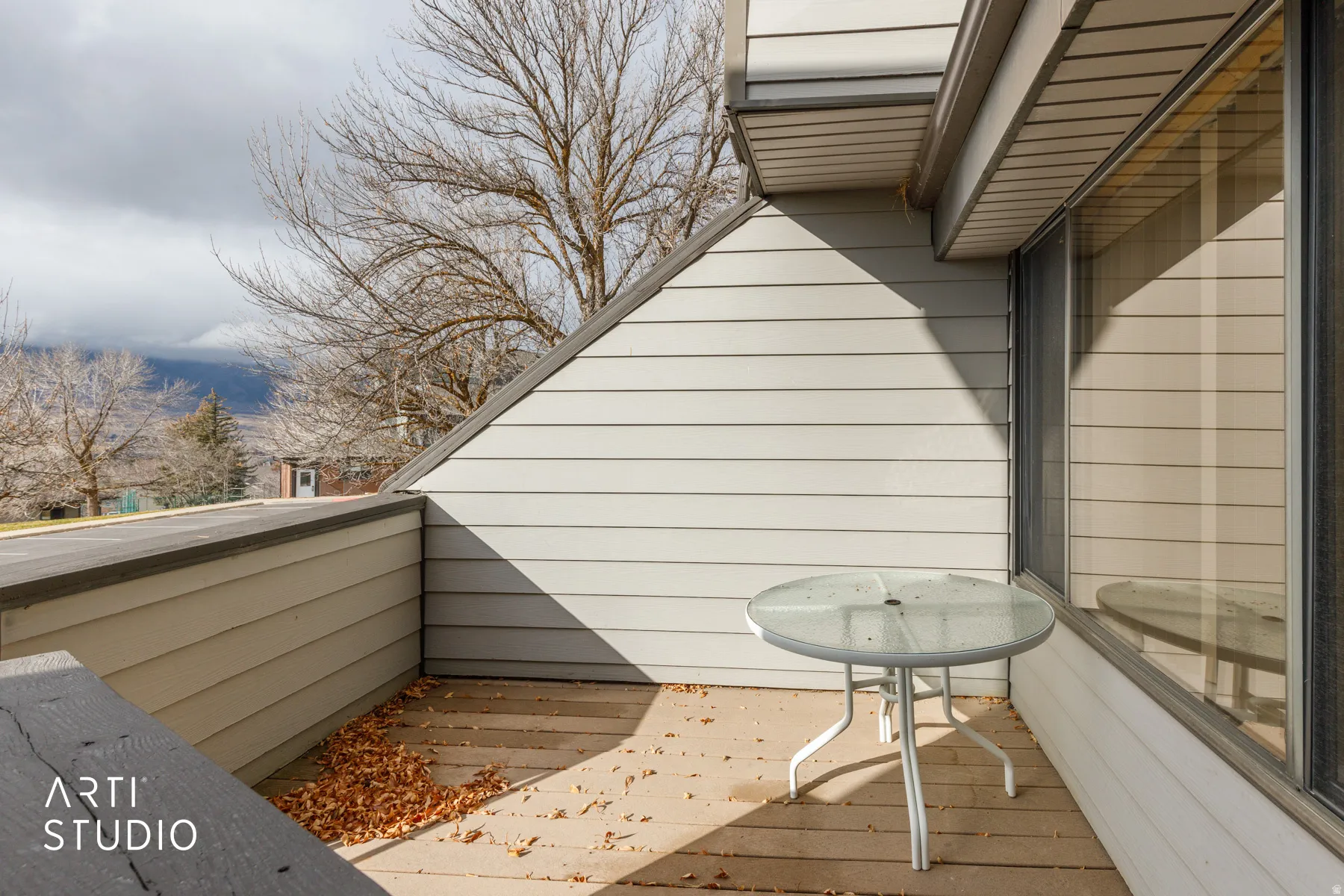 Private balcony with wood-finish flooring, horizontal siding, and a mountain backdrop