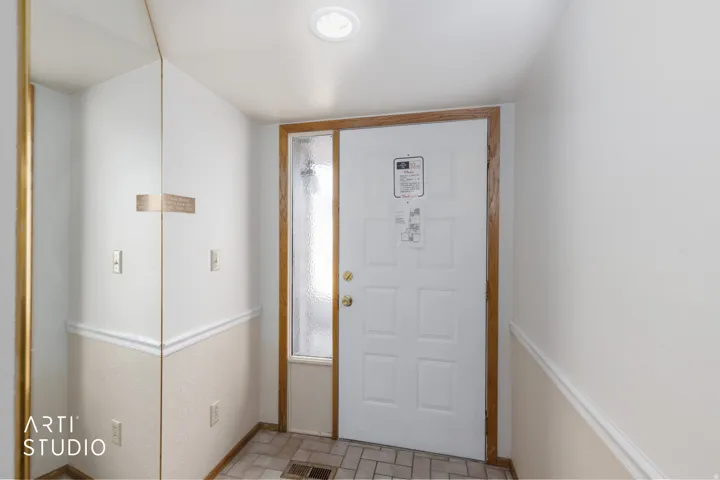 Entryway featuring a paneled door with wood trim, a textured glass sidelight, and recessed lighting