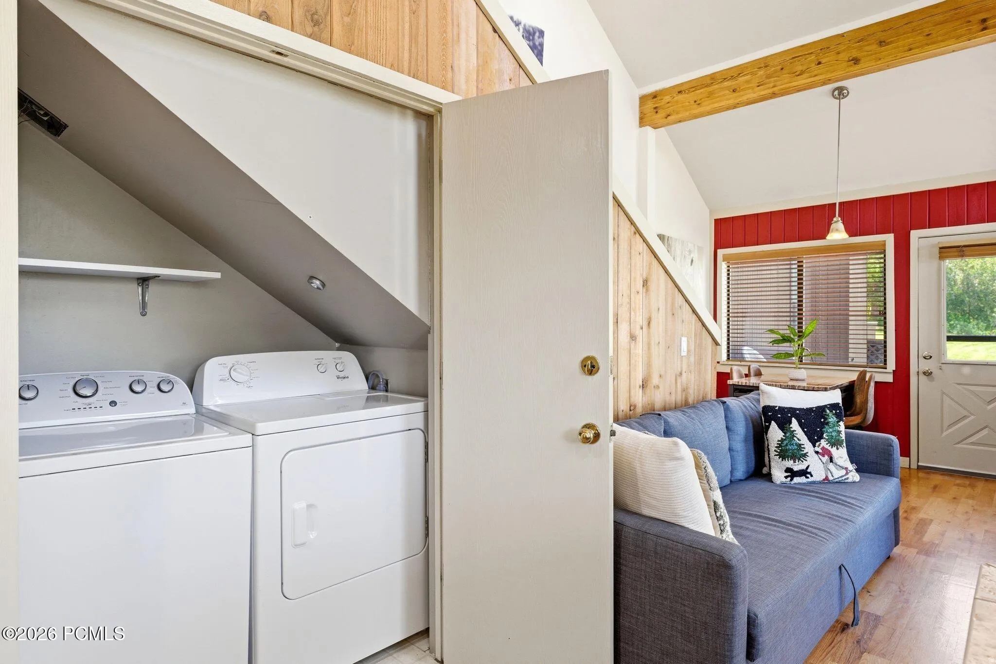 Dedicated laundry area featuring a washer and dryer beneath a sloped ceiling