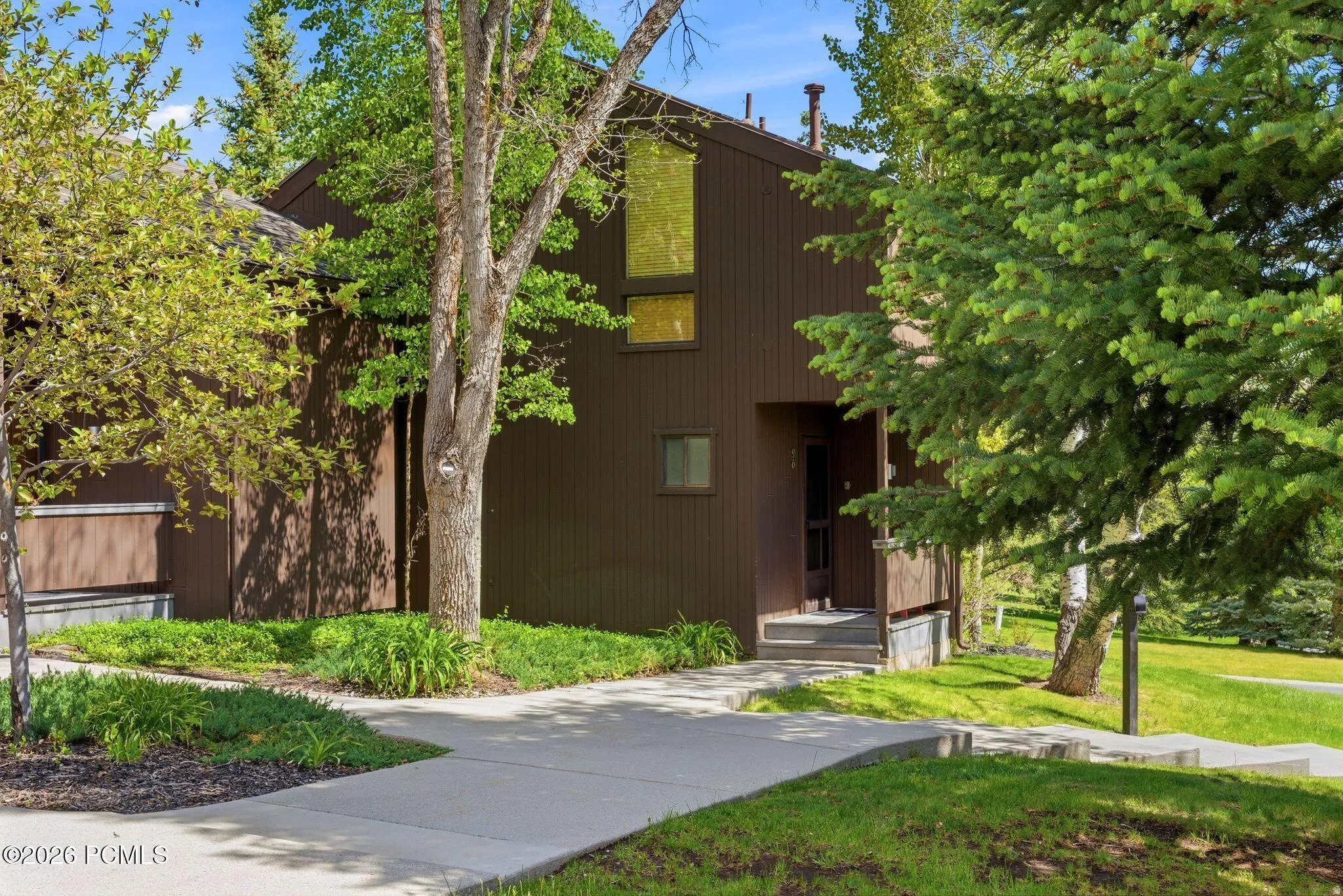 Brown-sided exterior featuring varied window placements and a covered entryway