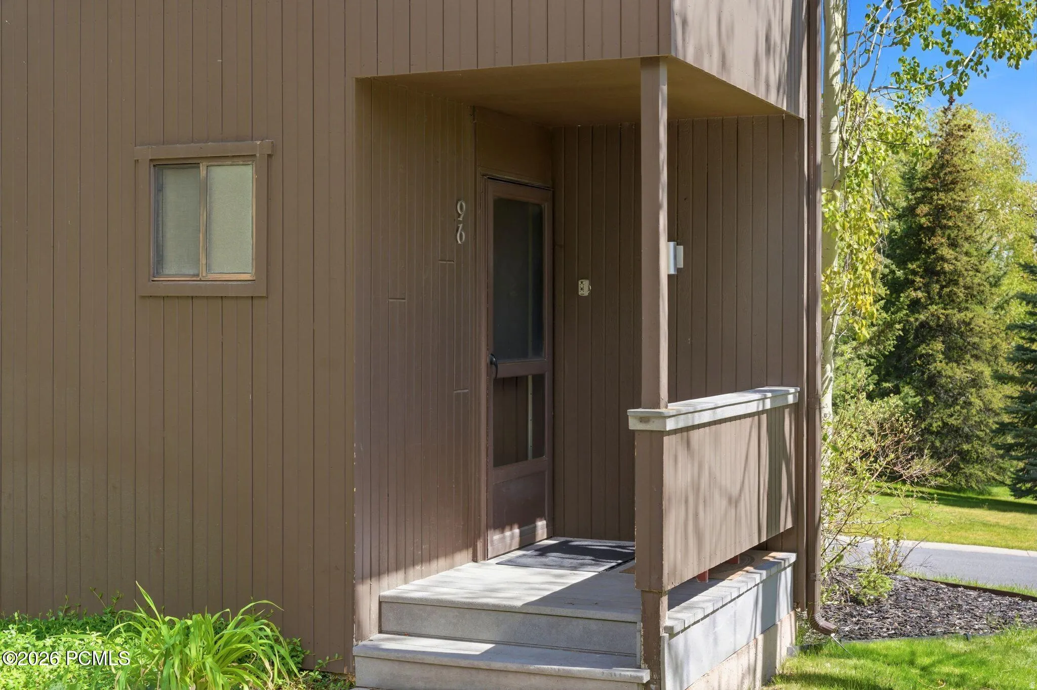 Exterior entry with vertical siding, a covered porch, and concrete steps