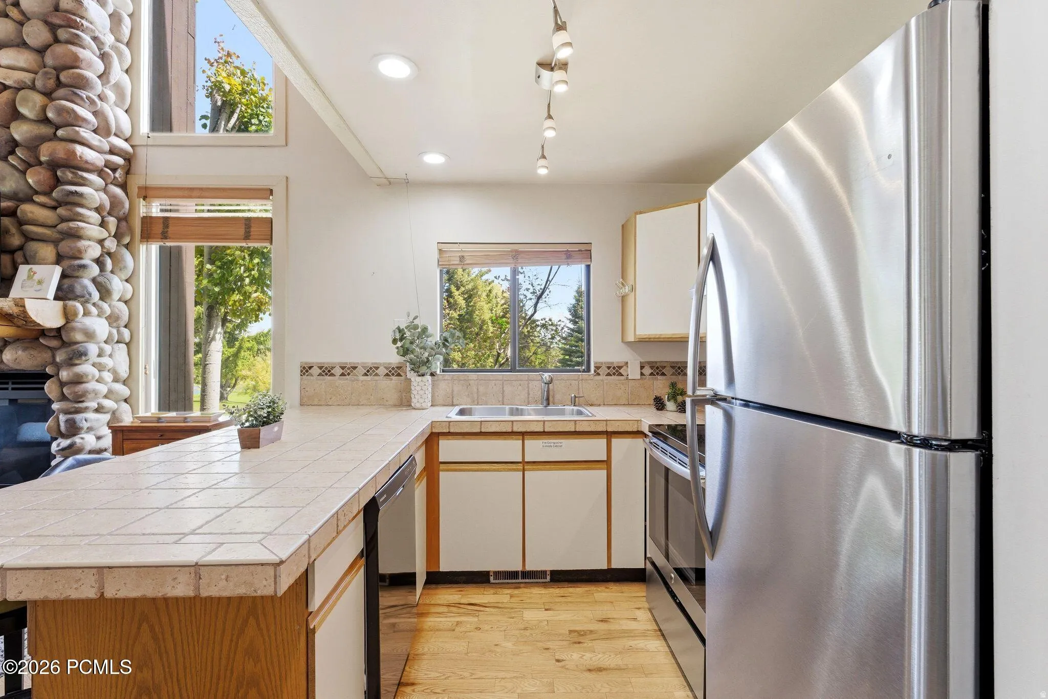 Kitchen with stainless steel appliances, including a refrigerator and range