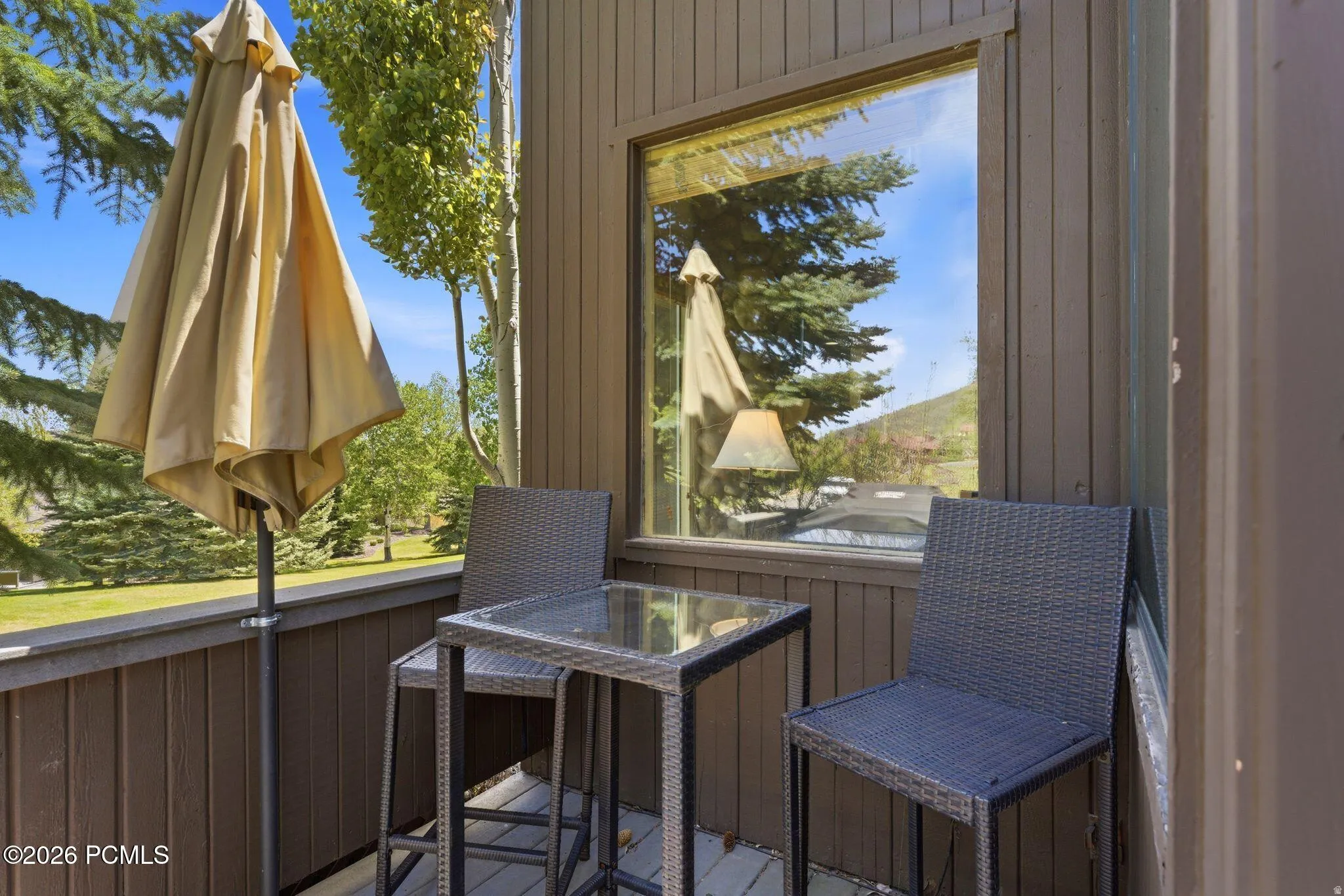 Private balcony with wood-finish decking and dark vertical siding