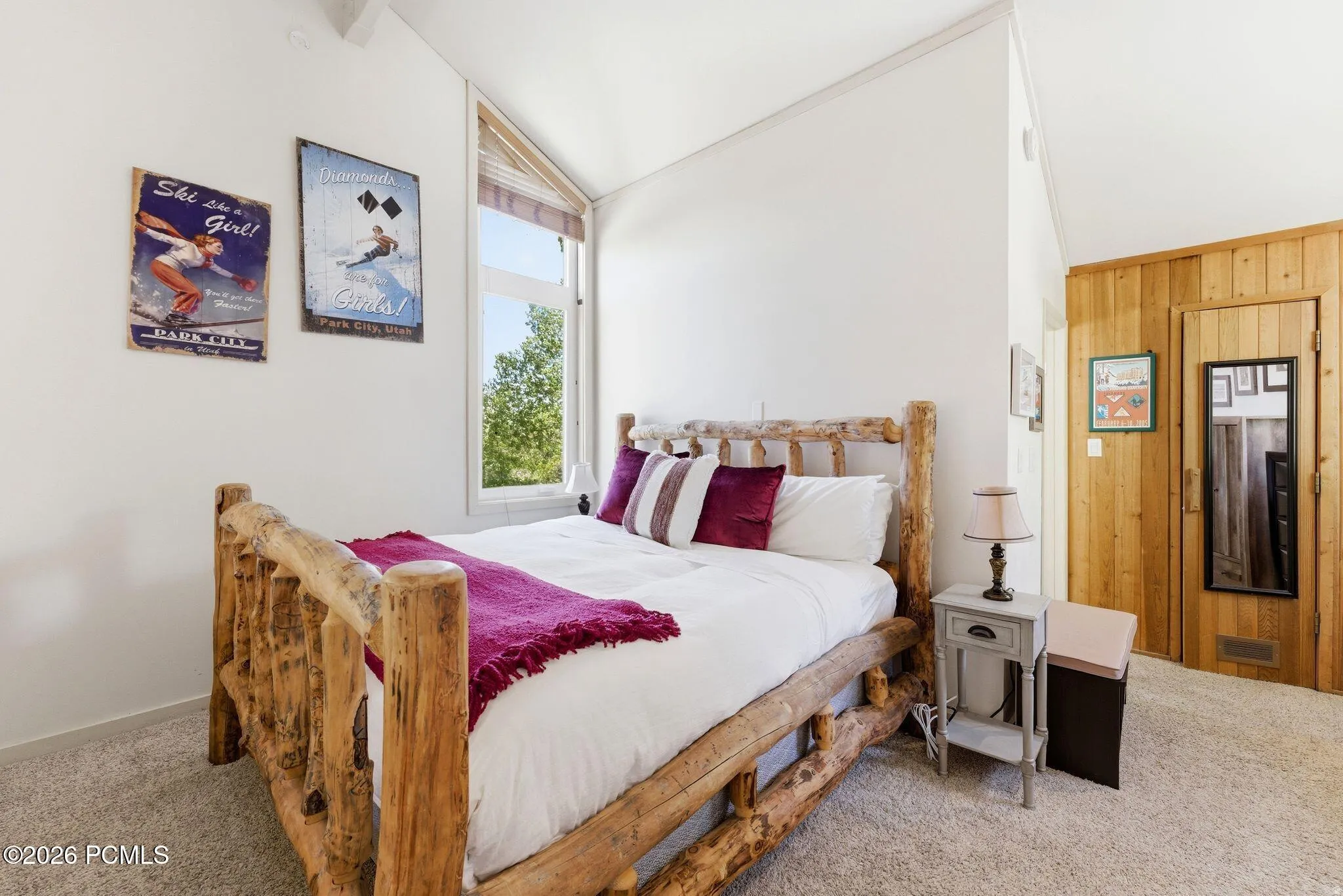 Room featuring a vaulted ceiling and a prominent large window