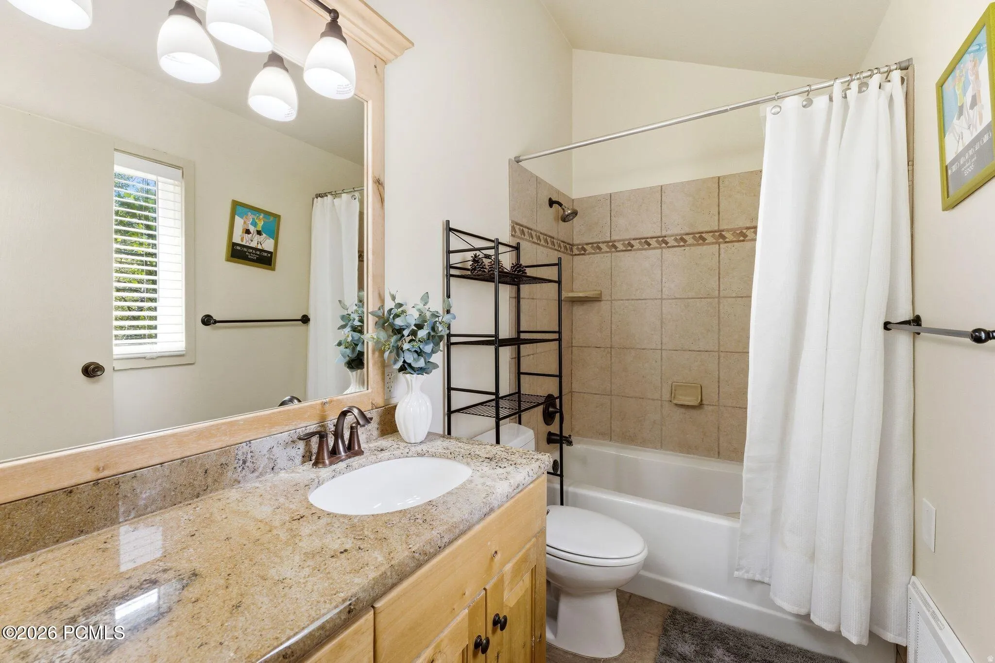 Full bathroom featuring a single vanity with a granite countertop, undermount sink, and wood-finish cabinetry