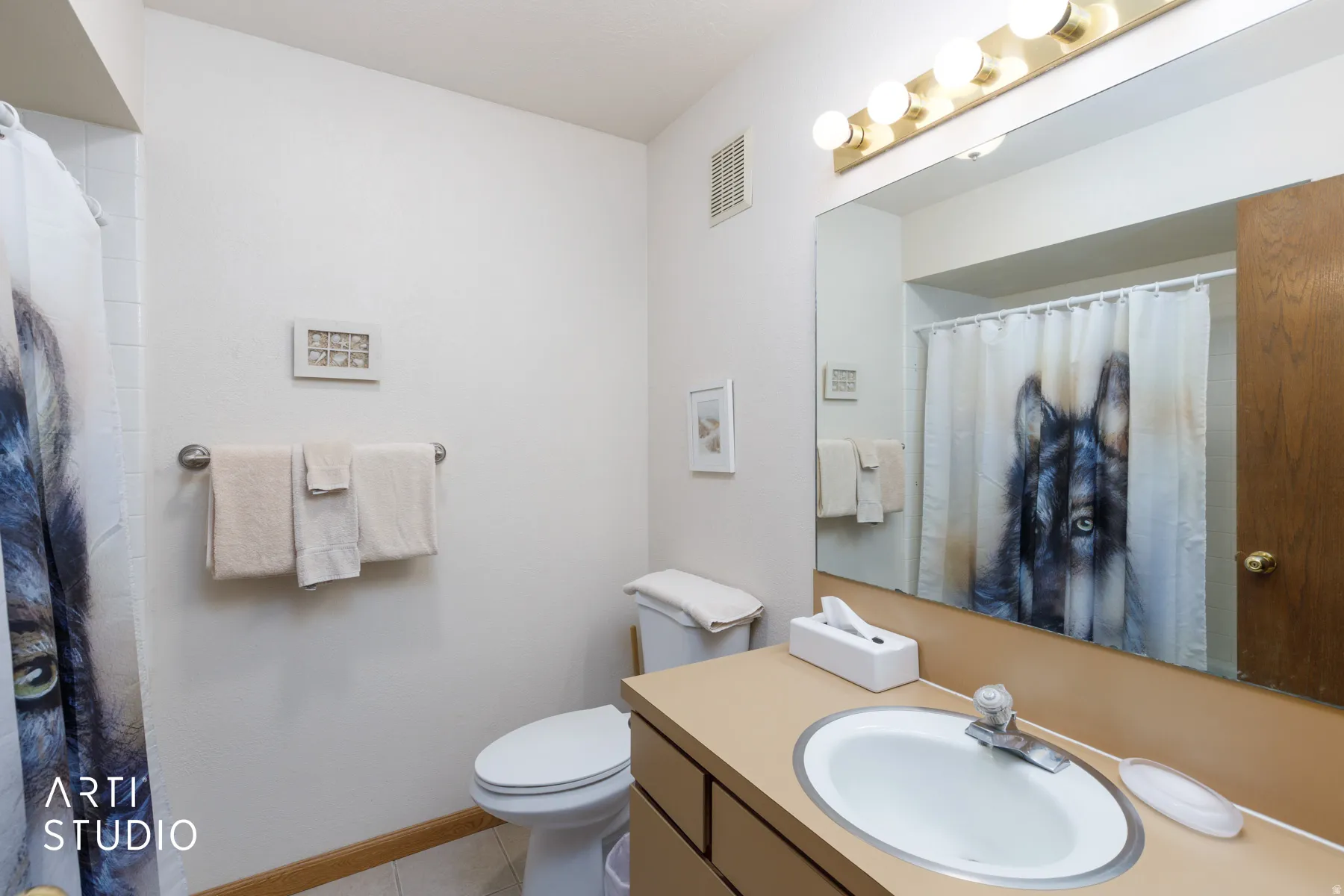 Bathroom vanity featuring an integrated sink, laminate countertop, and a large wall-mounted mirror