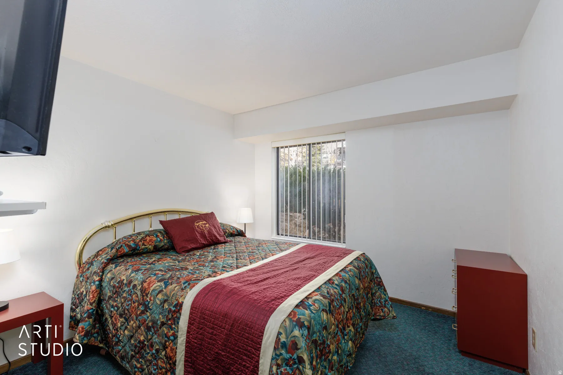 Bedroom featuring a window with vertical blinds, providing natural light