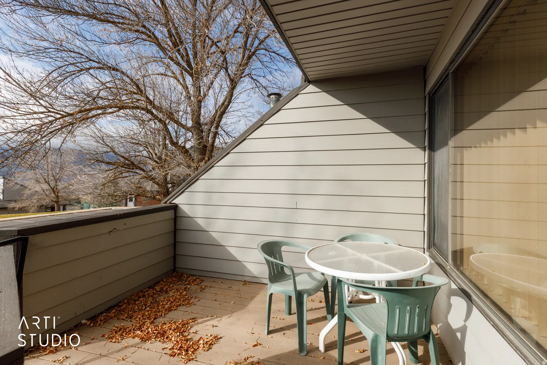 Private outdoor patio featuring a concrete surface, horizontal siding, and a large window