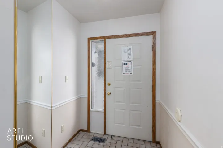 Entryway featuring a paneled door with wood-finish trim and an adjacent full-length sidelight