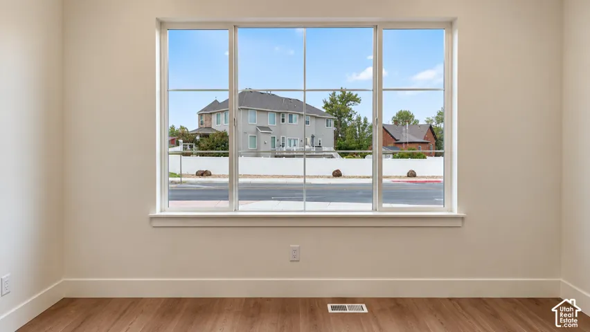 Large picture window with a multi-pane grid design, neutral interior paint, and wood-finish flooring